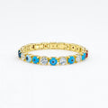 Gold tennis bracelet with alternating blue evil eye charms and clear gemstones on white background