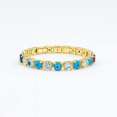 Gold tennis bracelet with alternating blue evil eye charms and clear gemstones on white background