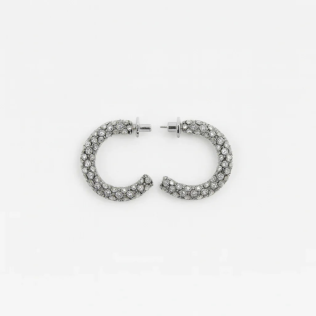 Pair of silver hoop earrings with clear rhinestones on a white background