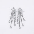 Silver star-shaped dangle earrings with crystal chains on white background