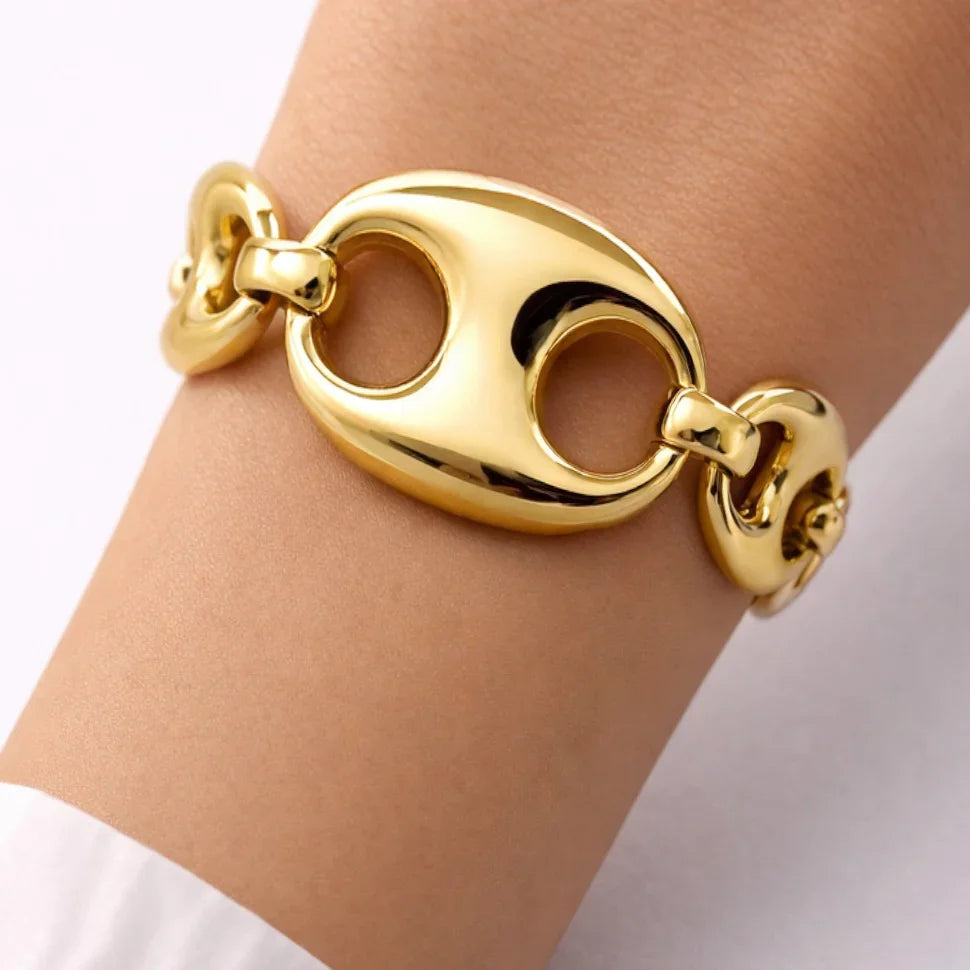 Chunky gold link bracelet with oval and round links on wrist, fashion jewelry close-up