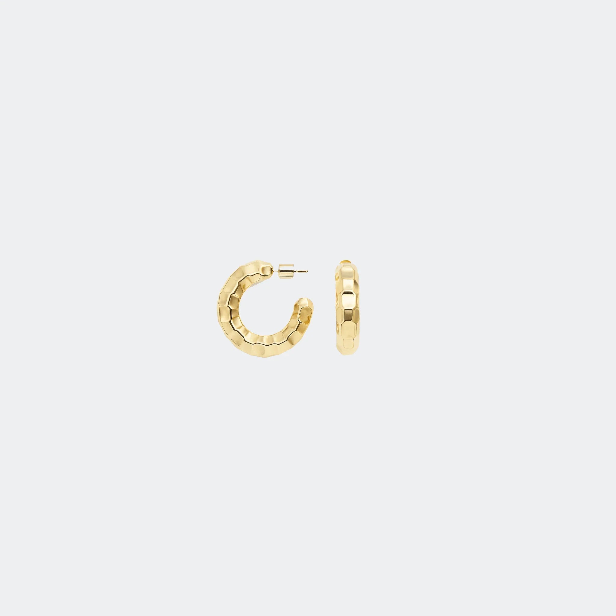 Textured gold hoop earrings on a plain light gray background