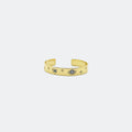 Gold open cuff bracelet with blue gemstone eye and star engravings on white background
