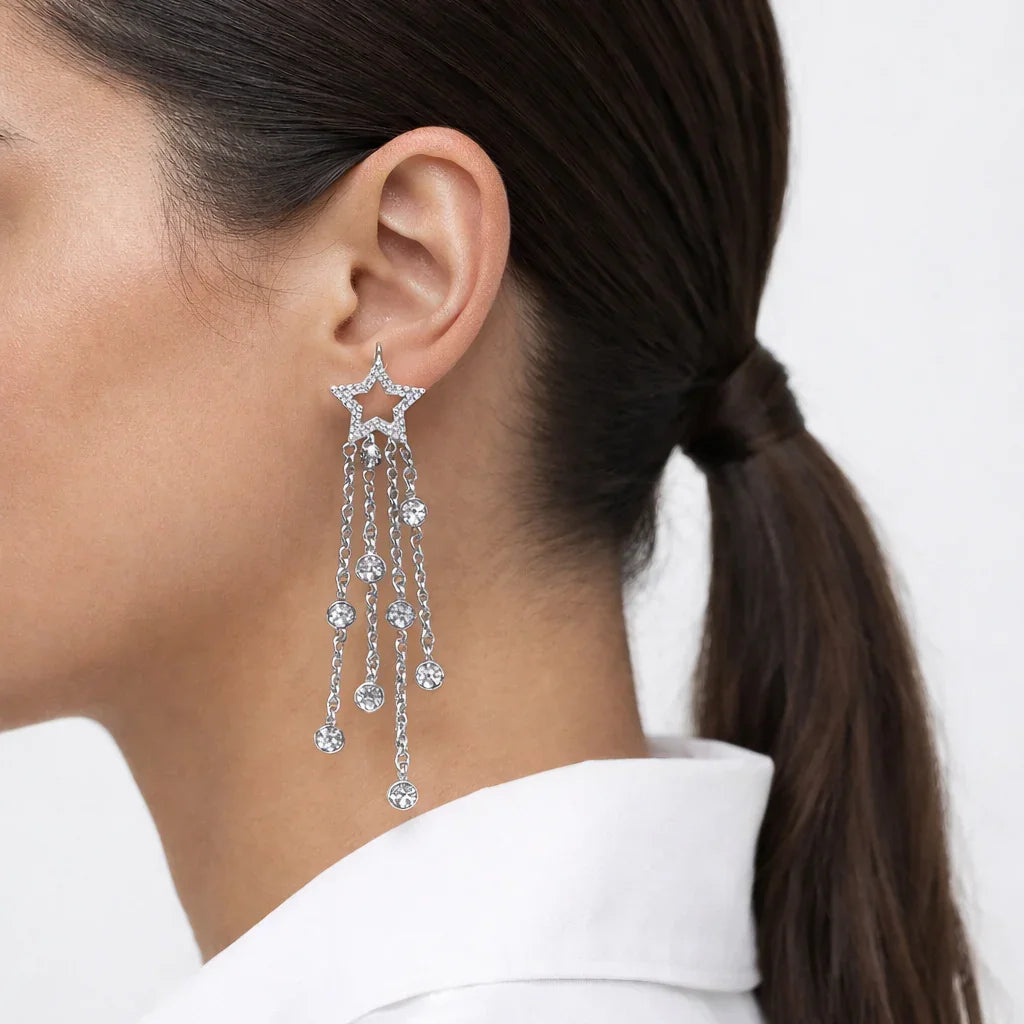 Woman wearing a star-shaped statement earring with dangling crystal chains