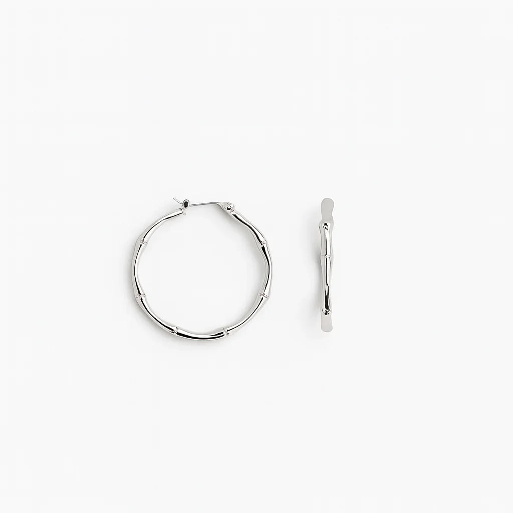 Silver bamboo-style hoop earrings on white background