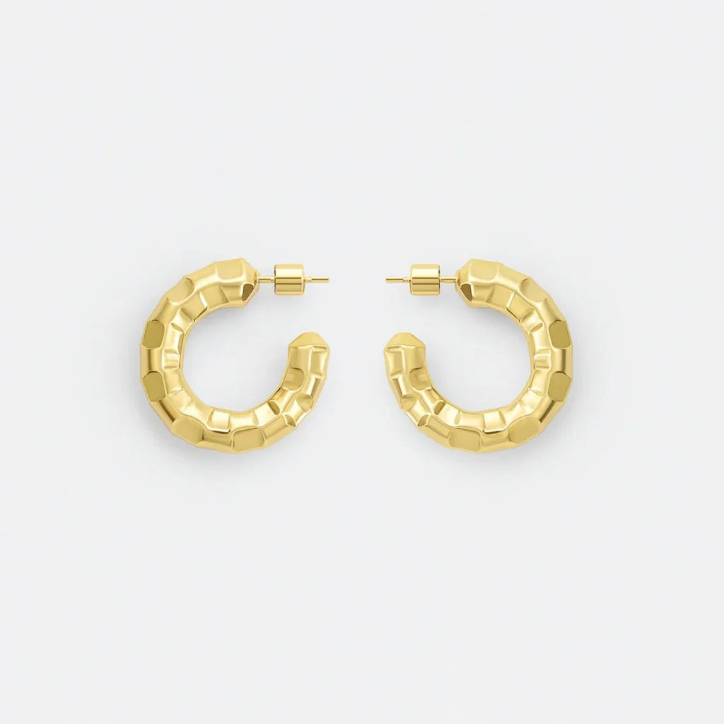 Chunky gold textured hoop earrings on white background