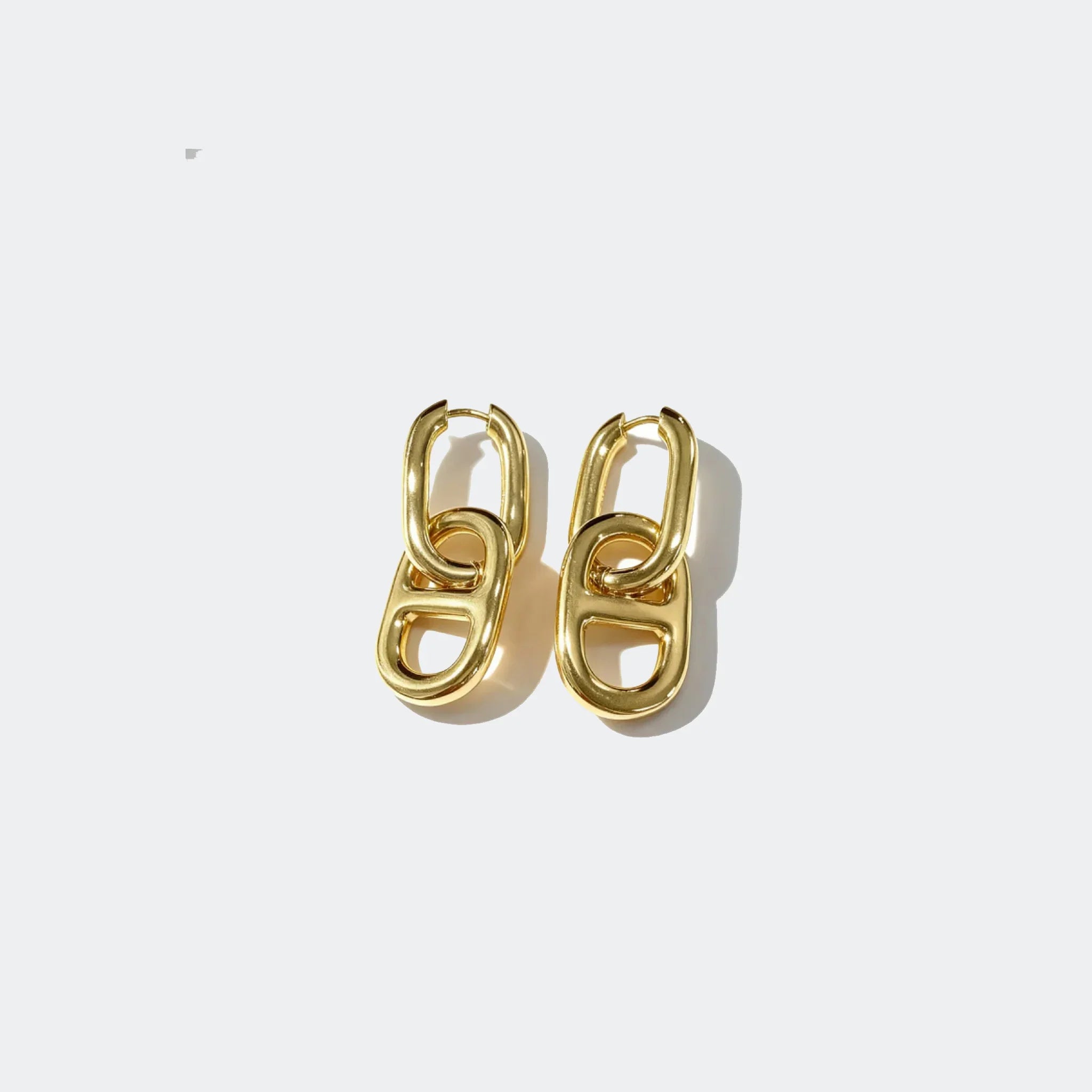 Gold chunky chain link earrings on a white background