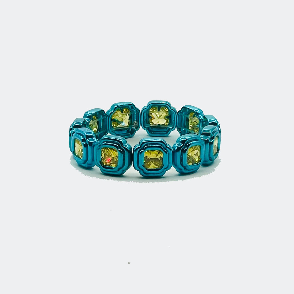 Blue eternity band with square yellow gemstones on white background