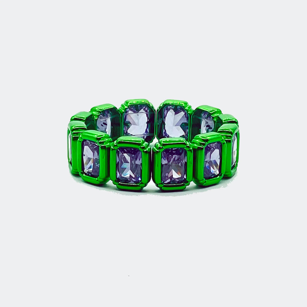 Green band ring with rectangular purple gemstones, modern jewelry on white background