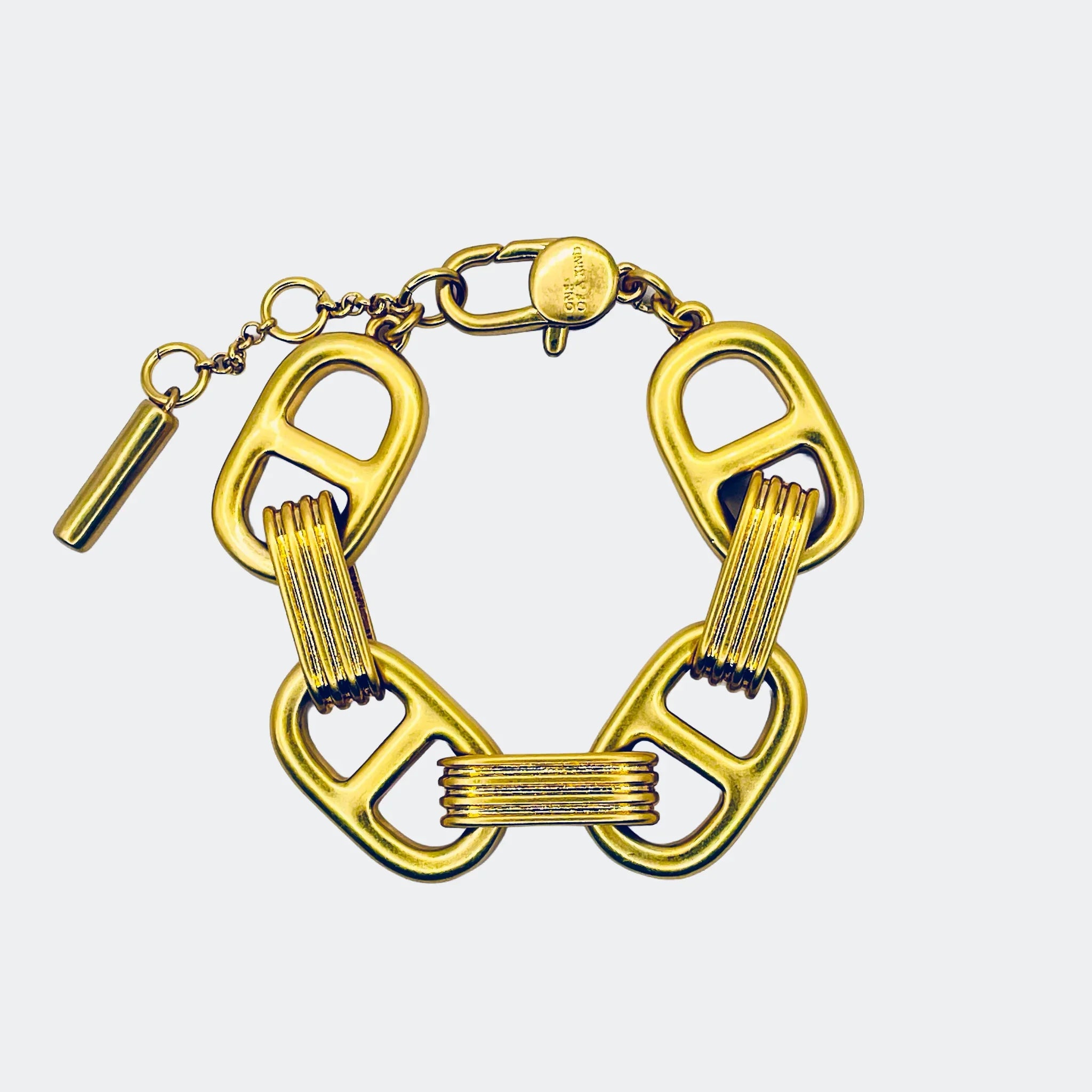 Bold gold link bracelet with geometric rectangular chain design on light background